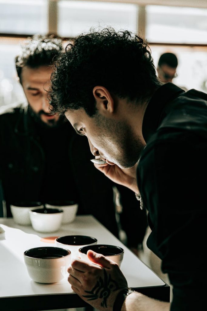 Man sipping coffee in a Baku café, engaged in a tasting session with friends.